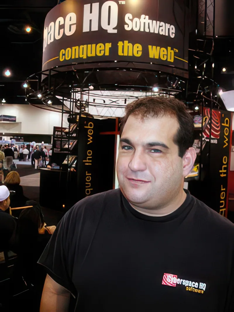 Michael Kovnick at the Cyberspace HQ Software booth at Comdex in Las Vegas, under a sign reading 'conquer the web'